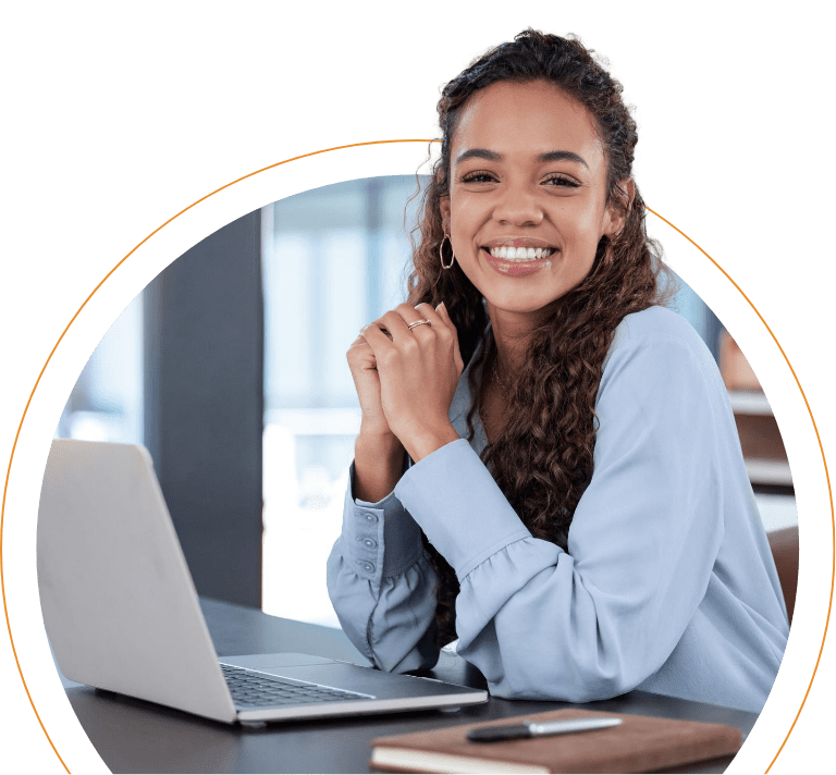 Mujer sonriente sentada frente a su laptop en un ambiente de oficin, mostrando el servicio de marketing digital